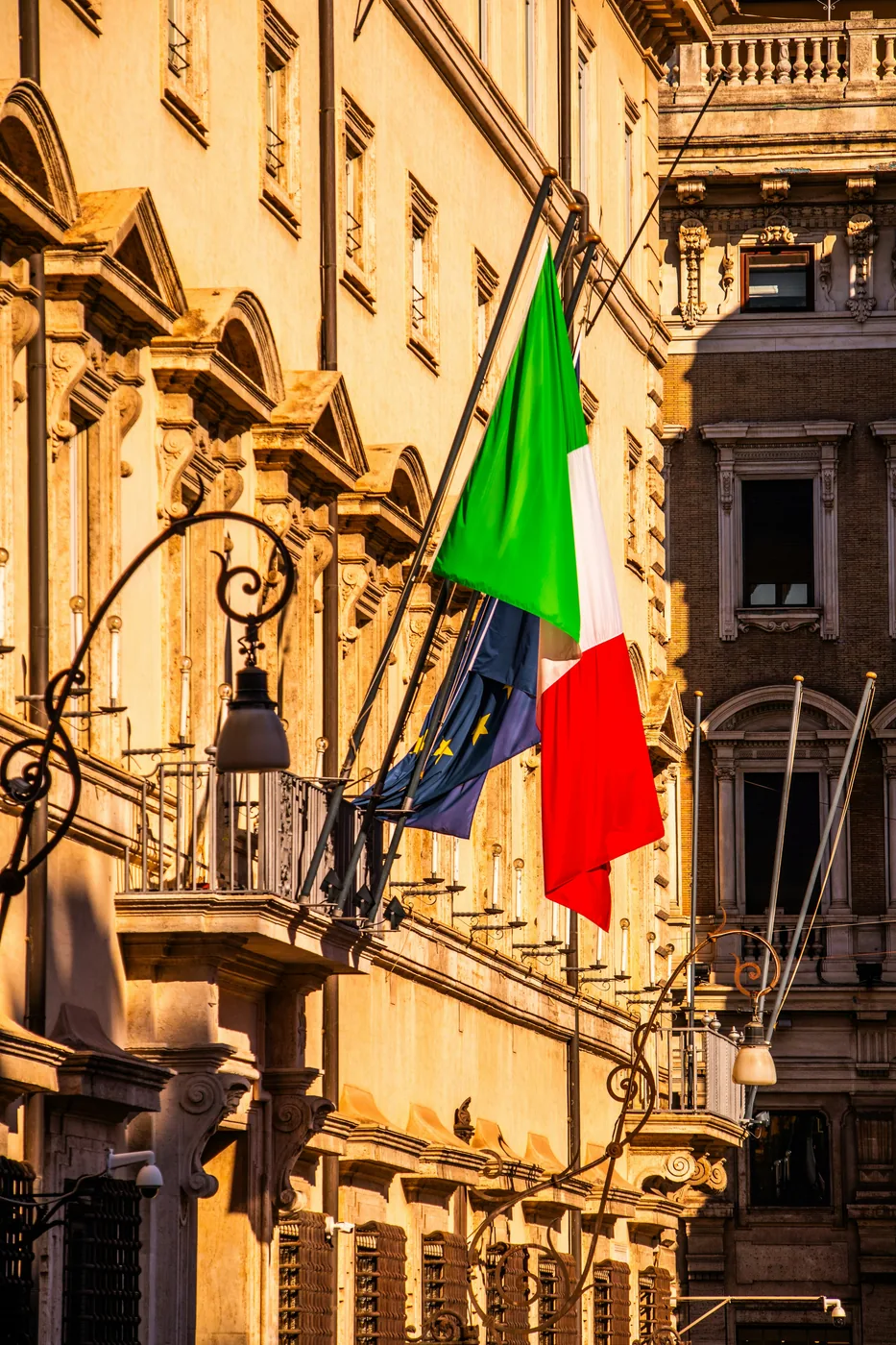 Italian and EU flags on a building in Rome — EU and non-EU quota strategy for Italian university admissions with AcademItaly