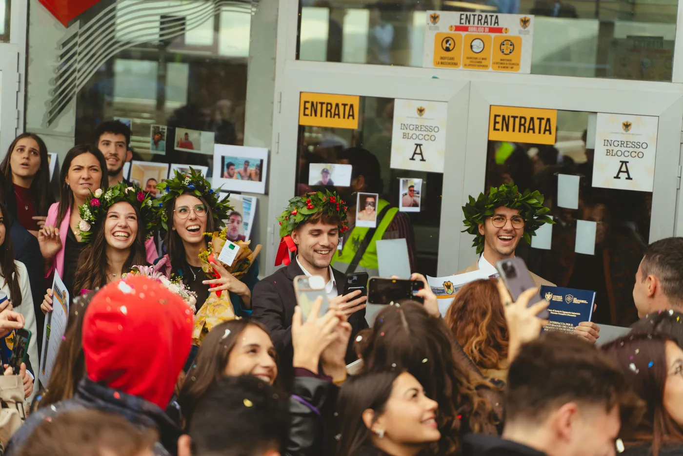 Graduates celebrating with laurel wreaths at an Italian university — private university admissions guidance from AcademItaly